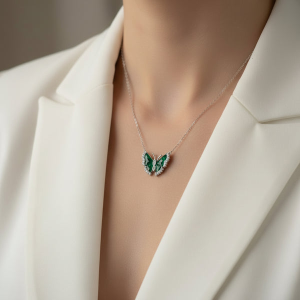 Butterfly-shaped necklace with green gemstones on a card labeled '92.5 Silver Jewellery'.